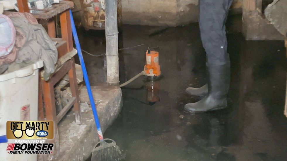 Marty Griffin stands in raw sewage in the basement of Tonya Todd