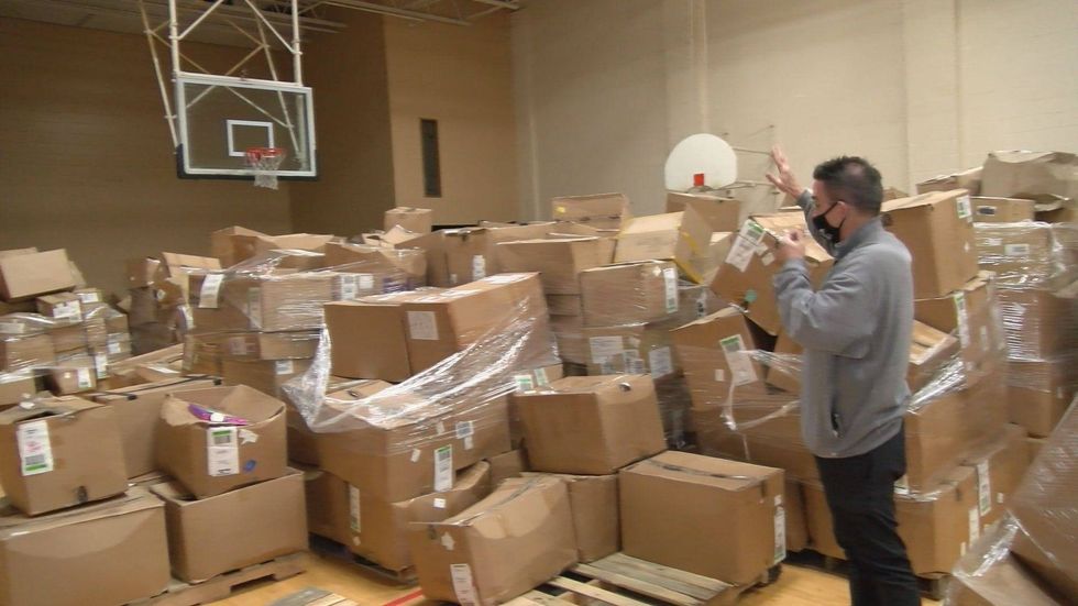 Marty stands among piles of donated boxes