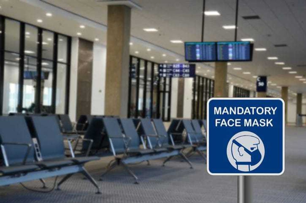 Mask mandate sign at an airport terminal.