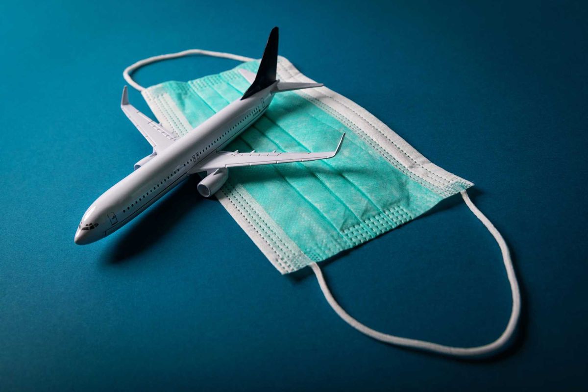 Mask on blue background with toy plane on top.