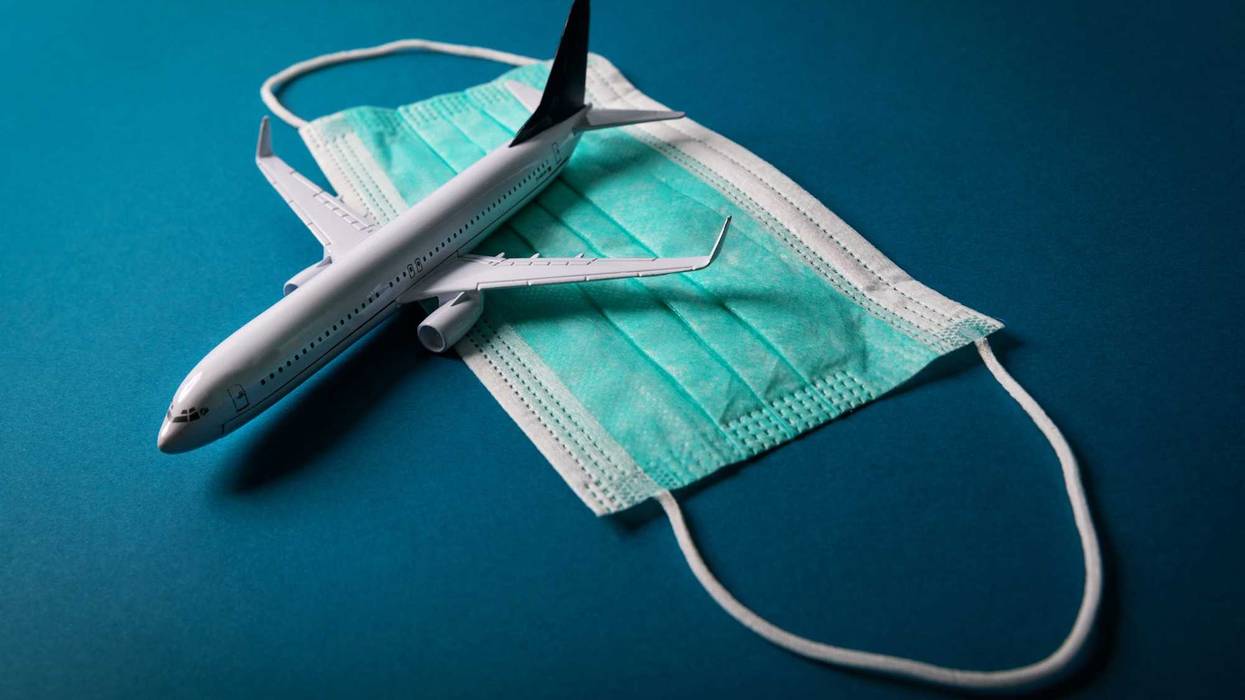 Mask on blue background with toy plane on top.
