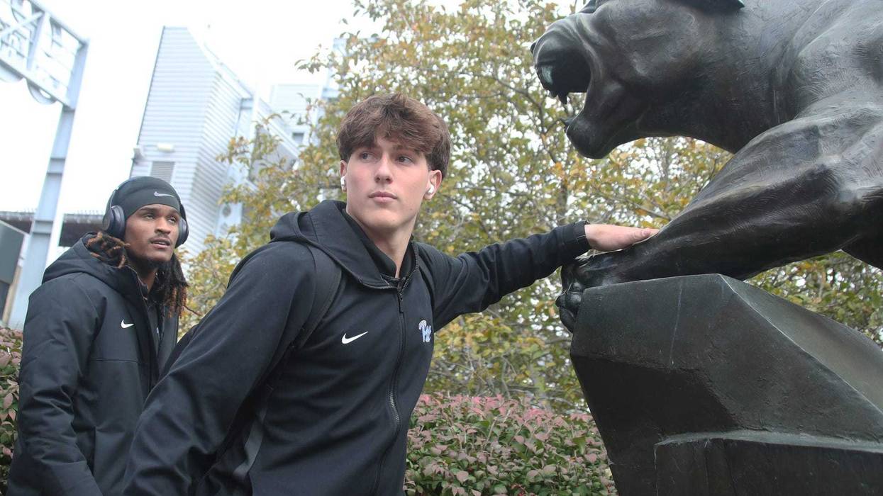 Mason Heintschel touching the Panthers statue
