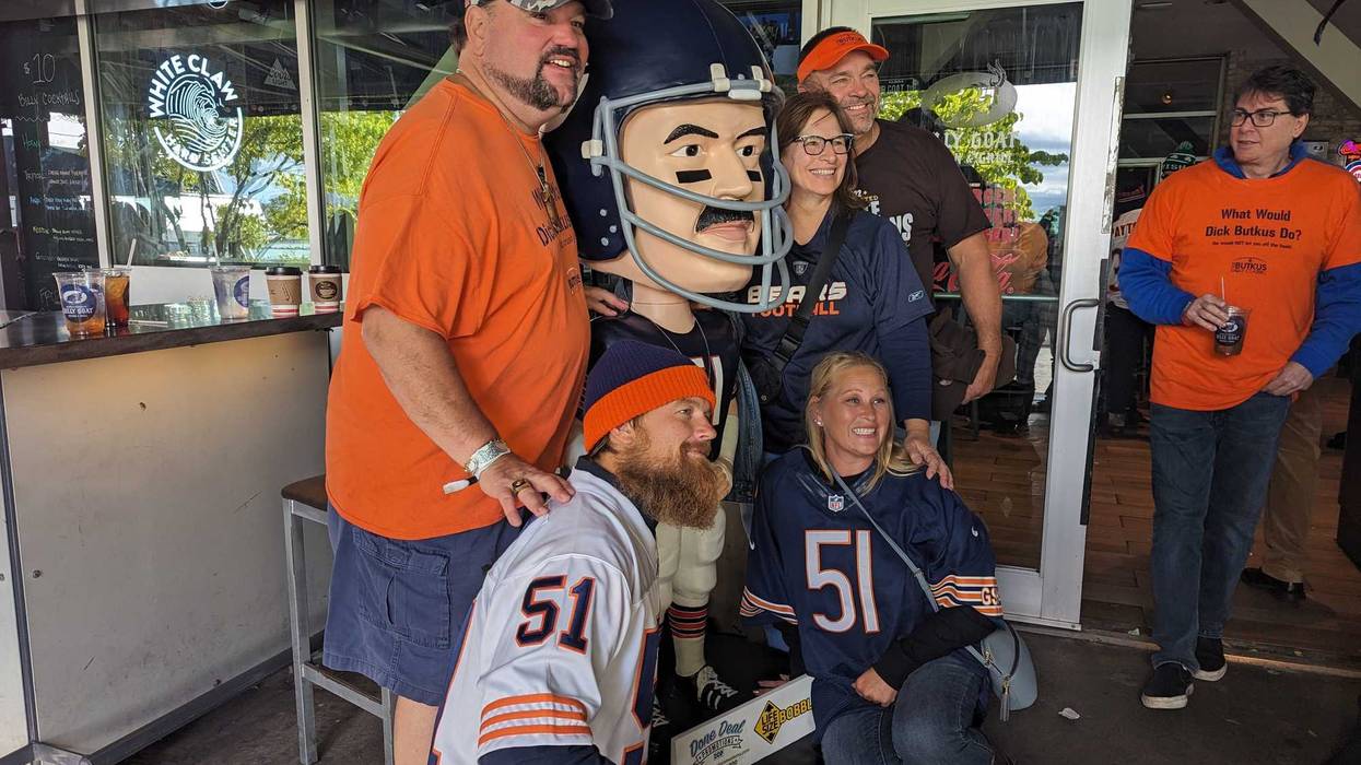 Matt Butkus (far left), poses with a bobblehead of his late father Dick Butkus at a tailgate honoring the legendary linebacker