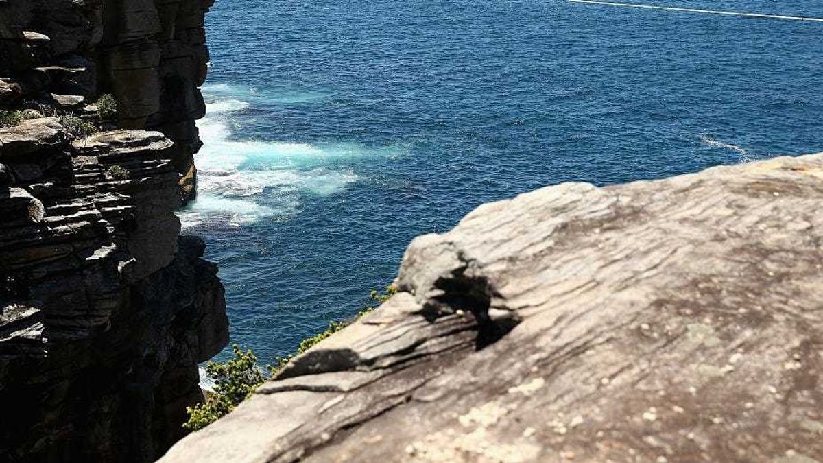 Matt Macelli walks along a slackline as he highlines between two cliffs on December 21, 2014 in Sydney, Australia.