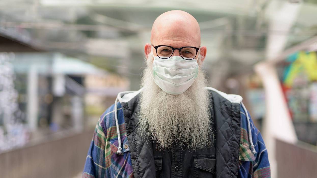 Mature bald bearded man with mask and eyeglasses for protection from corona virus outbreak and pollution