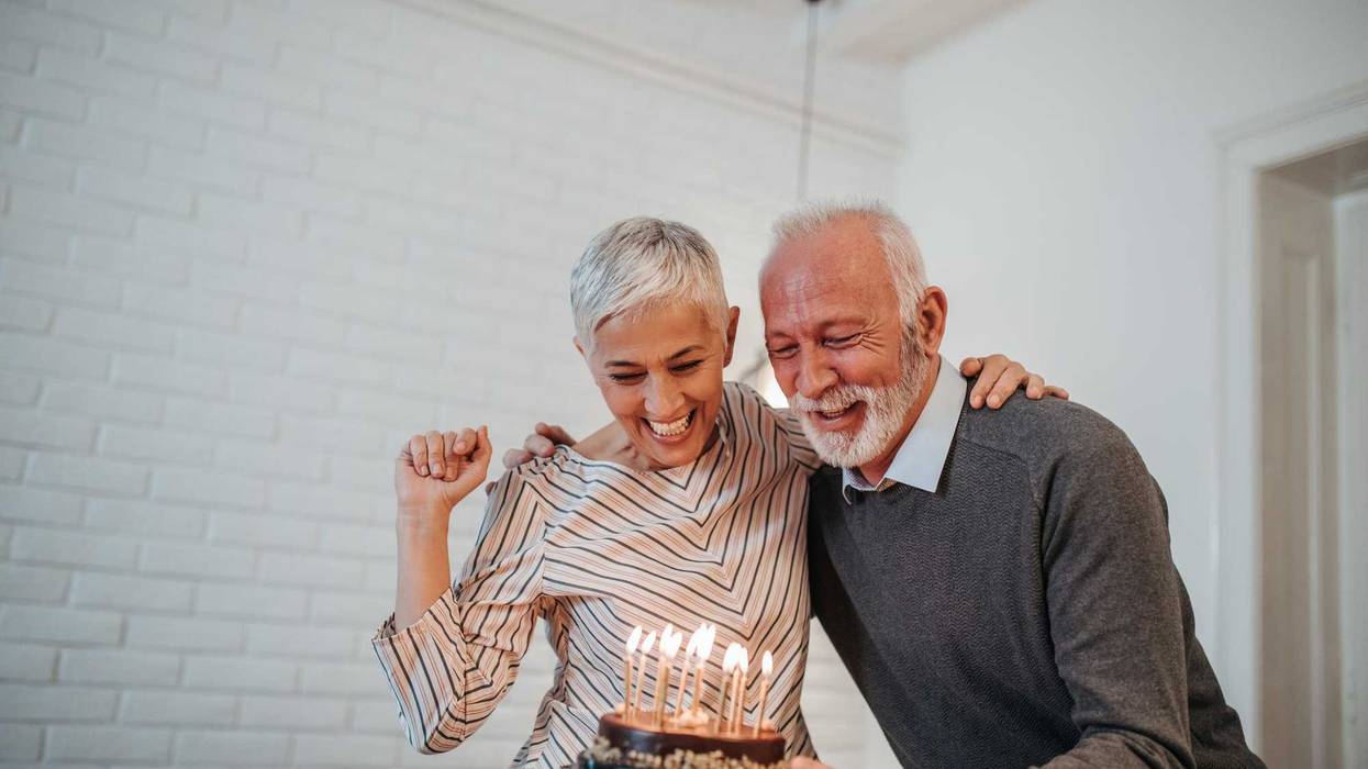 Mature couple celebrating holding a birthday cake