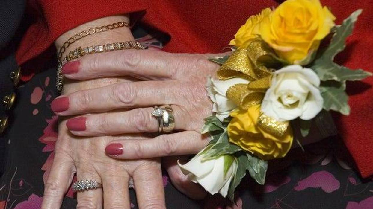 Mature woman's hands wearing ring and corsage