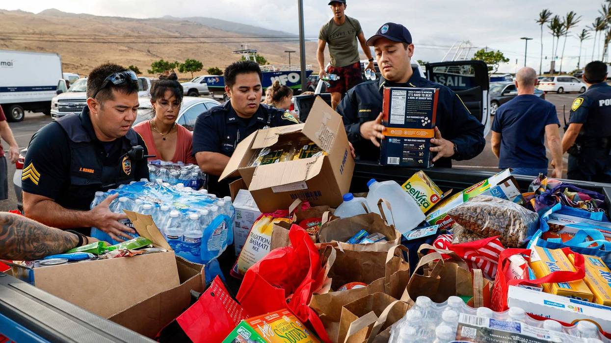 Maui police officers help pack truckloads of food and supplies in Maalaea, Maui on Aug. 10, 2023.