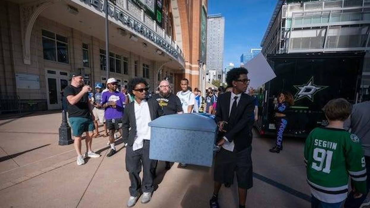 Mavs fans walking around the American Airlines Center carrying a coffin