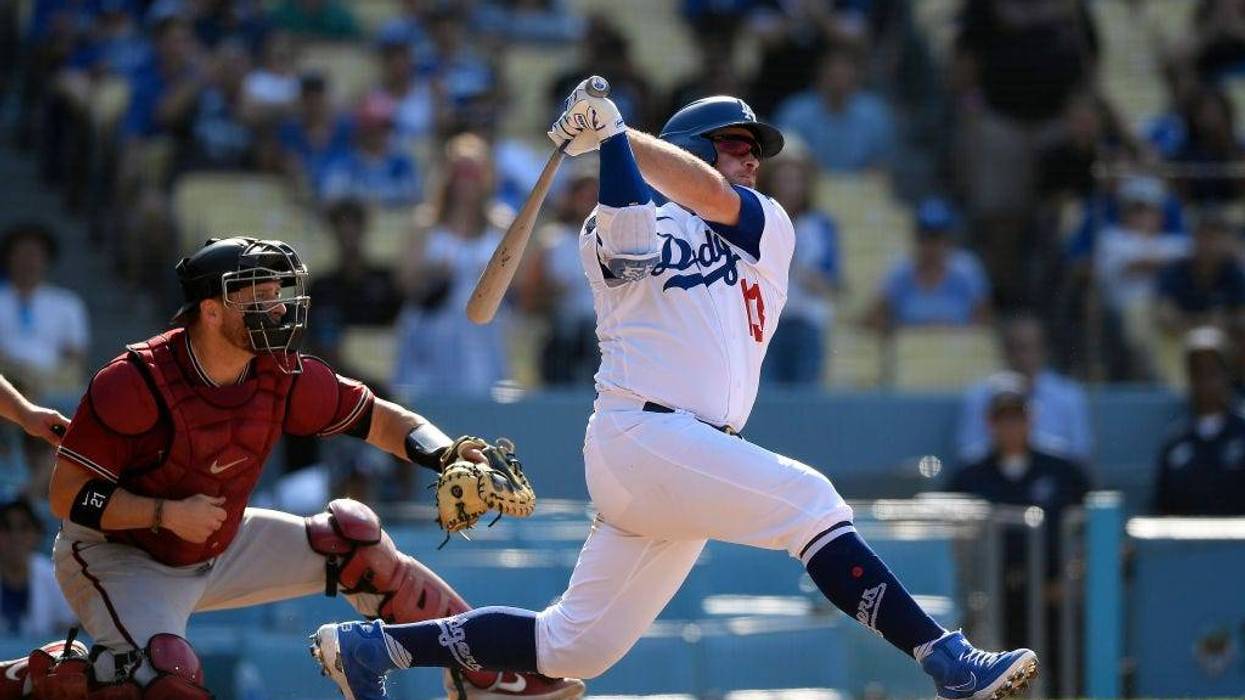 Max Muncy #13 of the Los Angeles Dodgers hits a walk-off, three-run home run during the ninth inning against the Arizona Diamondbacks at Dodger Stadium on July 11, 2021 in Los Angeles, California.