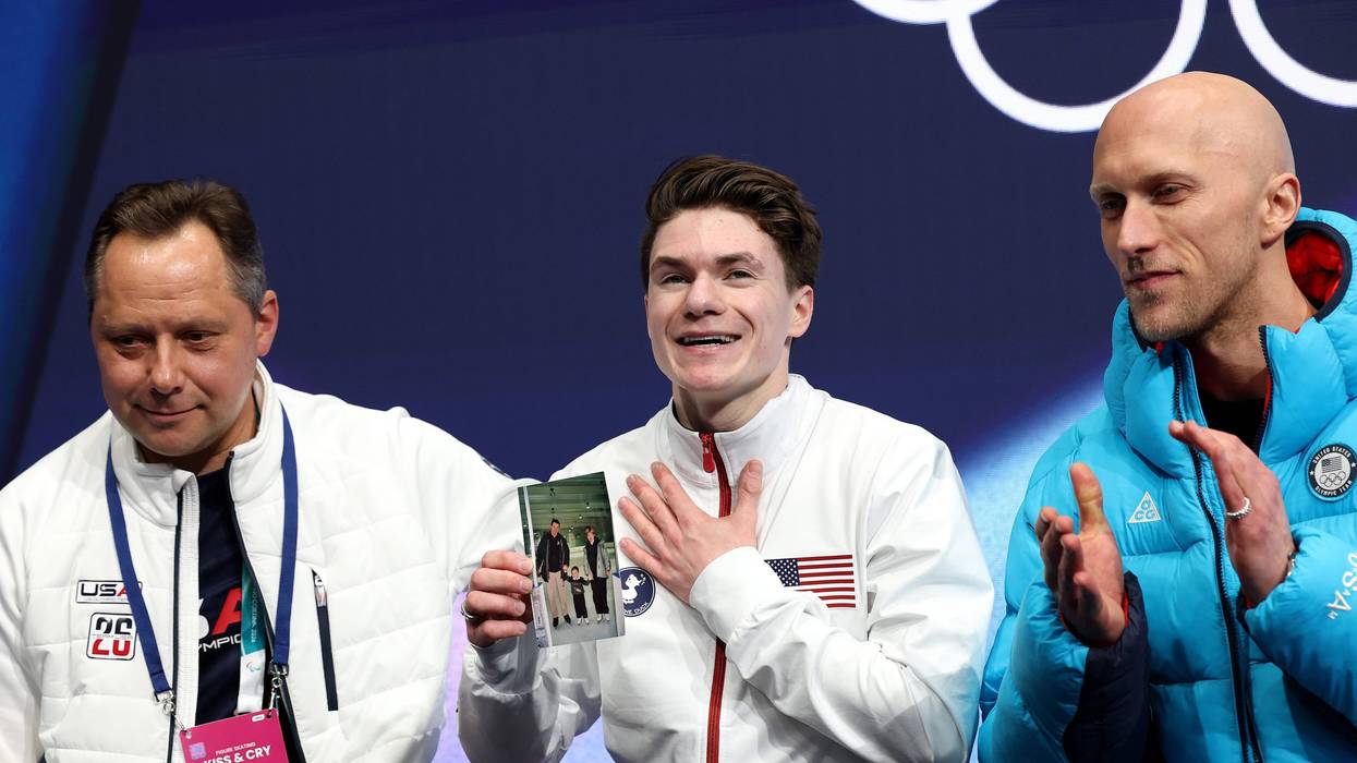 Maxim Naumov of USA, who grew up in Simsbury, reacts while holding a picture of his family after competing in Men's Single Skating - Short Program on day four of the Winter Olympics in Milan, Italy.