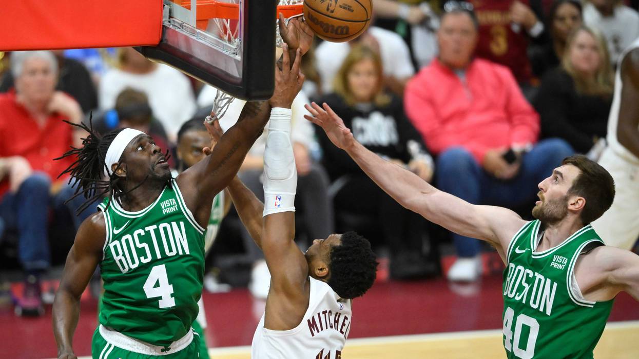 May 11, 2024; Cleveland, Ohio, USA; Cleveland Cavaliers guard Donovan Mitchell (45) shoots the ball against Boston Celtics guard Jrue Holiday (4) and center Luke Kornet (40) in the third quarter of game three of the second round of the 2024 NBA playoffs at Rocket Mortgage FieldHouse.