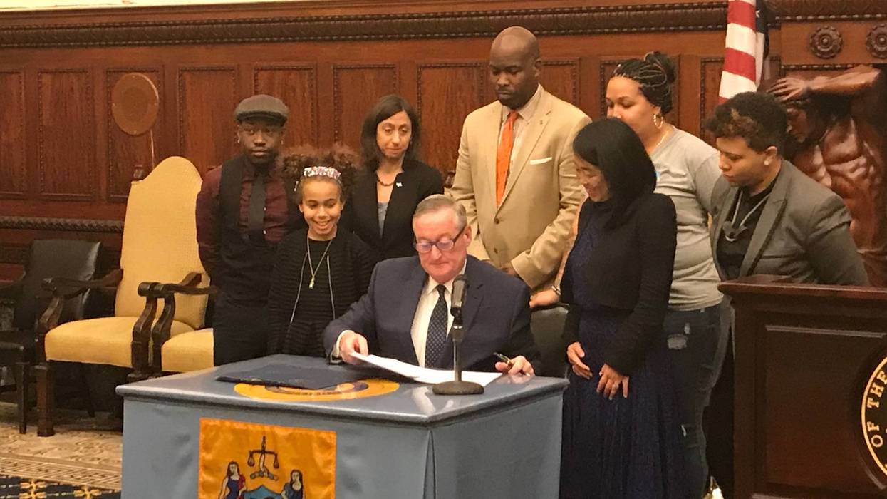 Mayor Jim Kenney, flanked by 10-yuear-old Itzela and Councilmember-at-Large Helen Gym, signs bills intended to protect transgender and gender nonbinary youth.