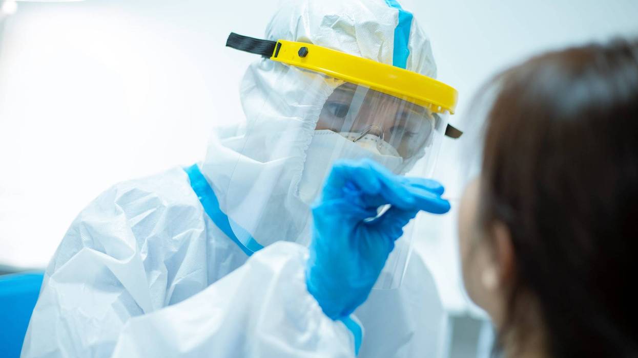 Medical worker taking a swab for a coronavirus sample from a potentially infected woman.