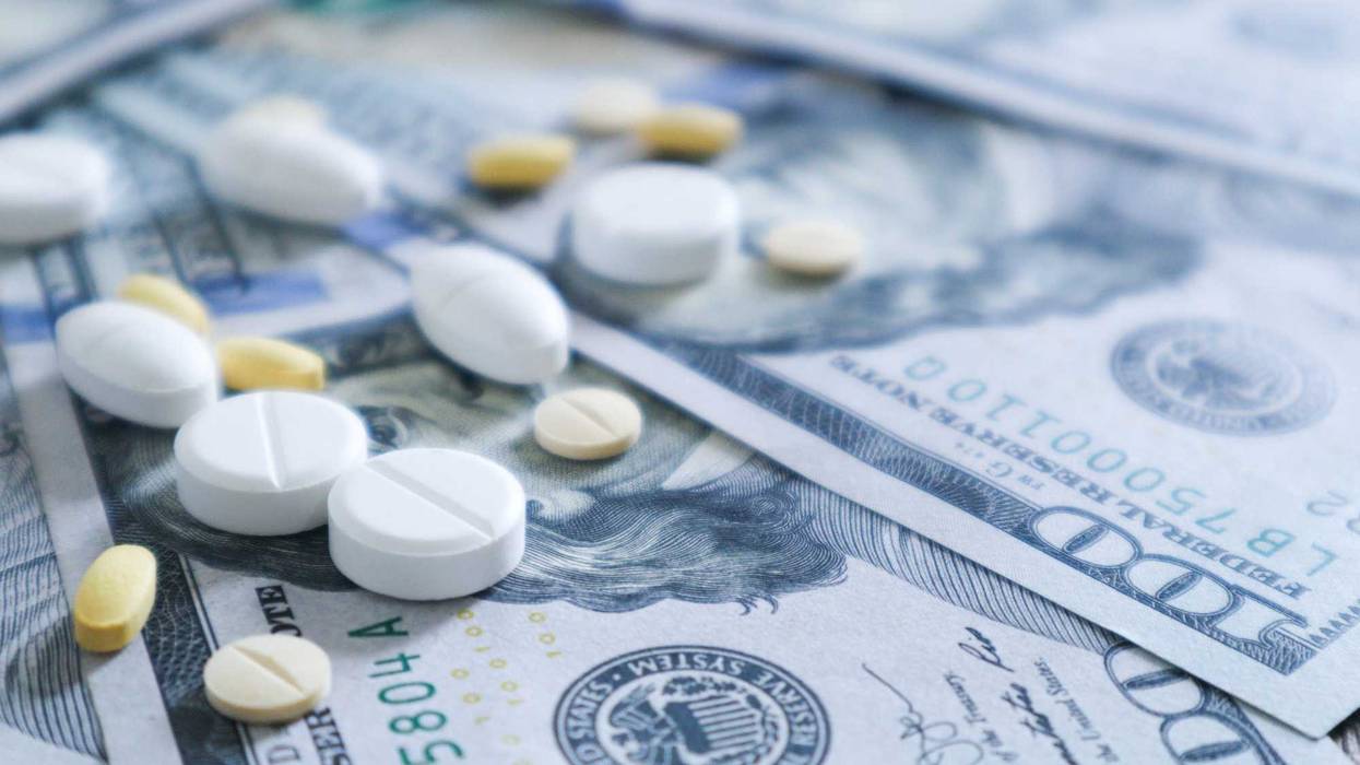 Medicine on top of hundred dollar bills.