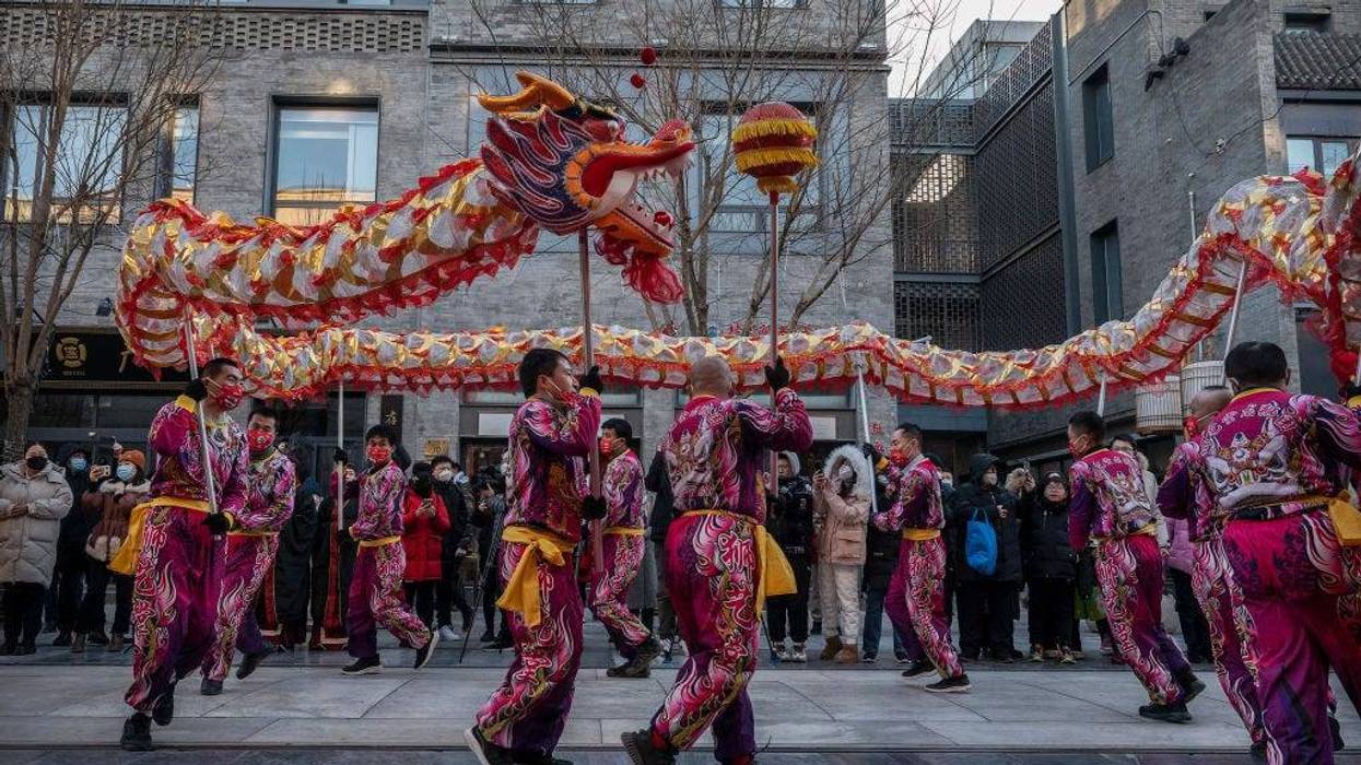Members of a dragon dance troupe perform at the opening of a clothing store in a shopping area during Chinese Lunar New Year and Spring Festival activities on January 27, 2023 in Beijing, China.