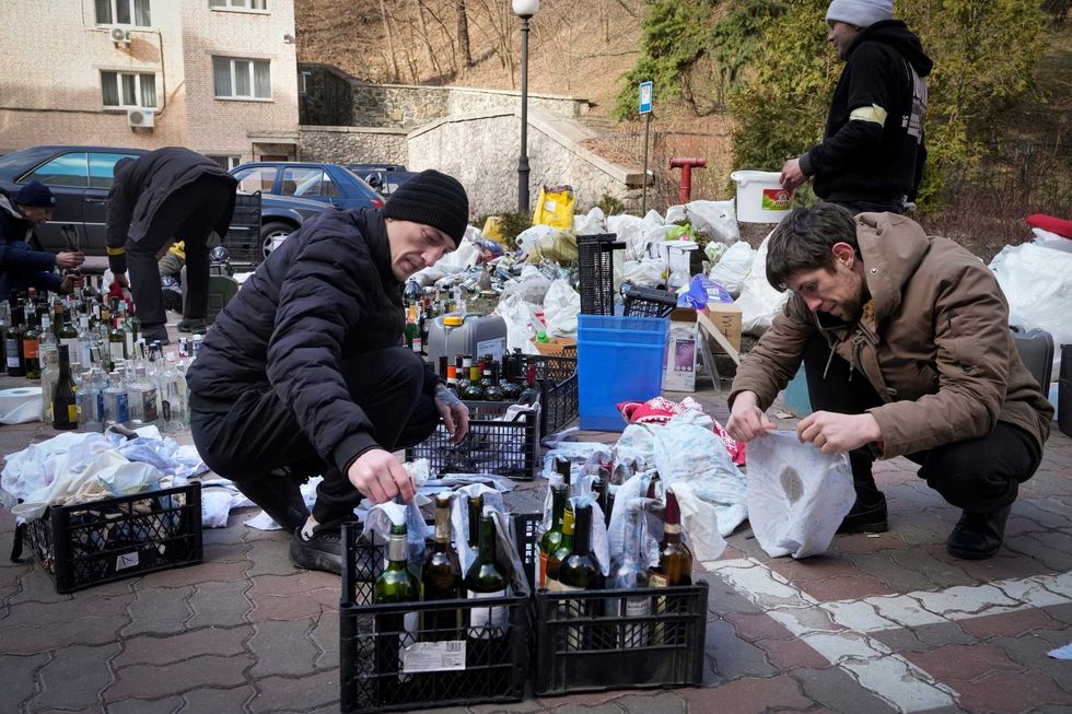 Members of civil defense prepare Molotov cocktails in a yard in Kyiv, Ukraine, Sunday, Feb. 27, 2022