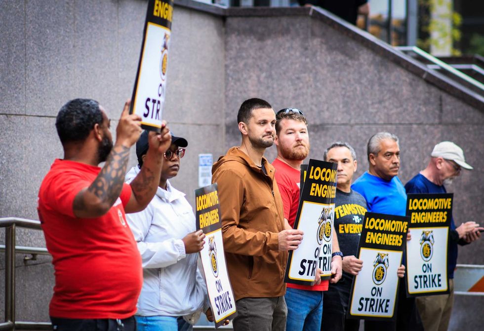 Members of the Brotherhood of Locomotive Engineers and Trainmen BLET Union Hold posters as they take part during a Strike outside NJ Transit