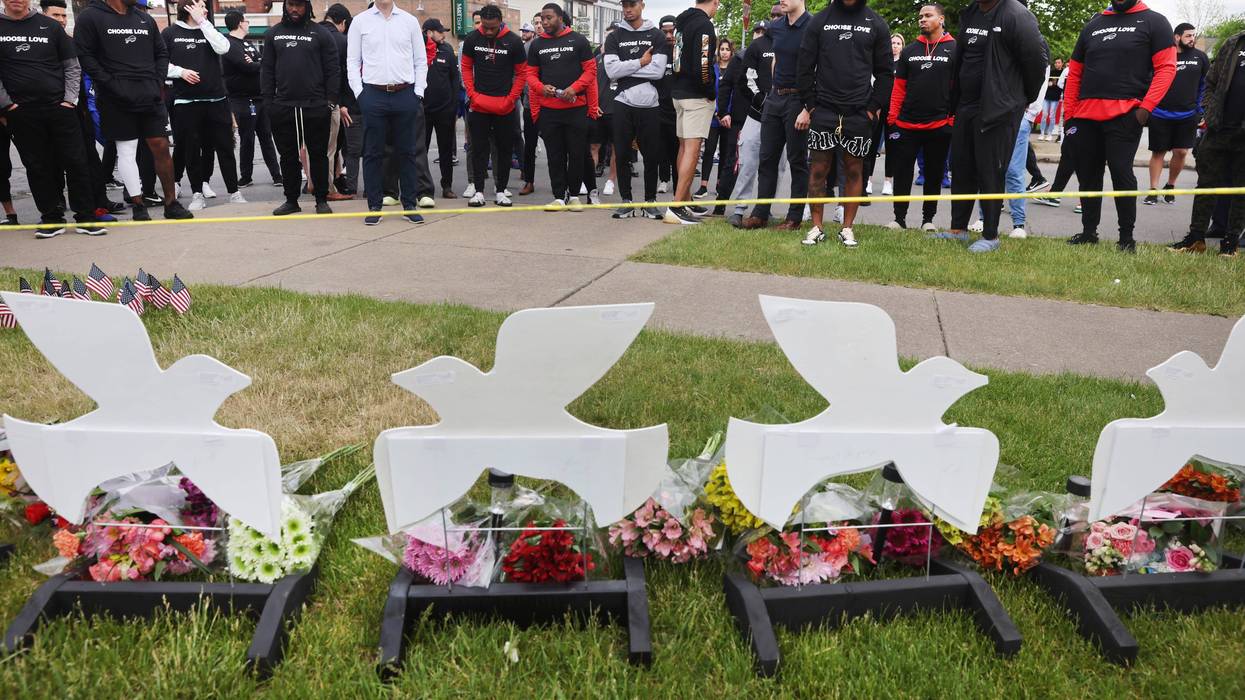 Members of the Buffalo Bills lay flowers at a memorial near the Tops supermarket where ten people were killed last Saturday on May 18, 2022 in Buffalo, New York.