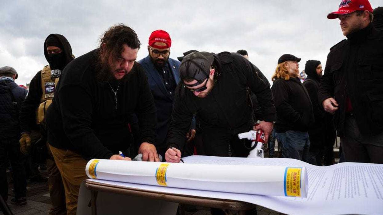 Members of the far-right group known as the Proud Boys sign a document on the grounds of the Capitol Building on January 6, 2021 in Washington, DC.