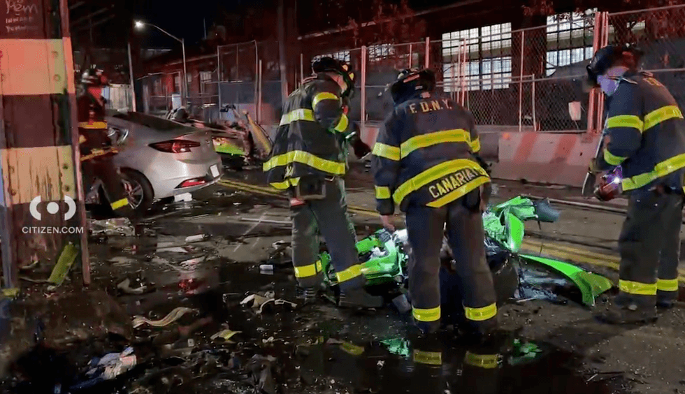 Members of the FDNY inspect the charred remains of the Lamborghini