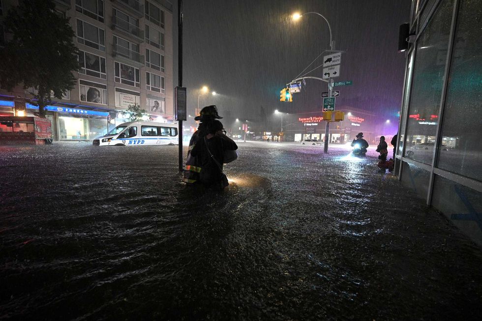 Members of the FDNY wade through waist high water caused by flash flooding brought by the remnants of hurricane Ida, in the New York City borough of Queens, NY, September 1, 2021