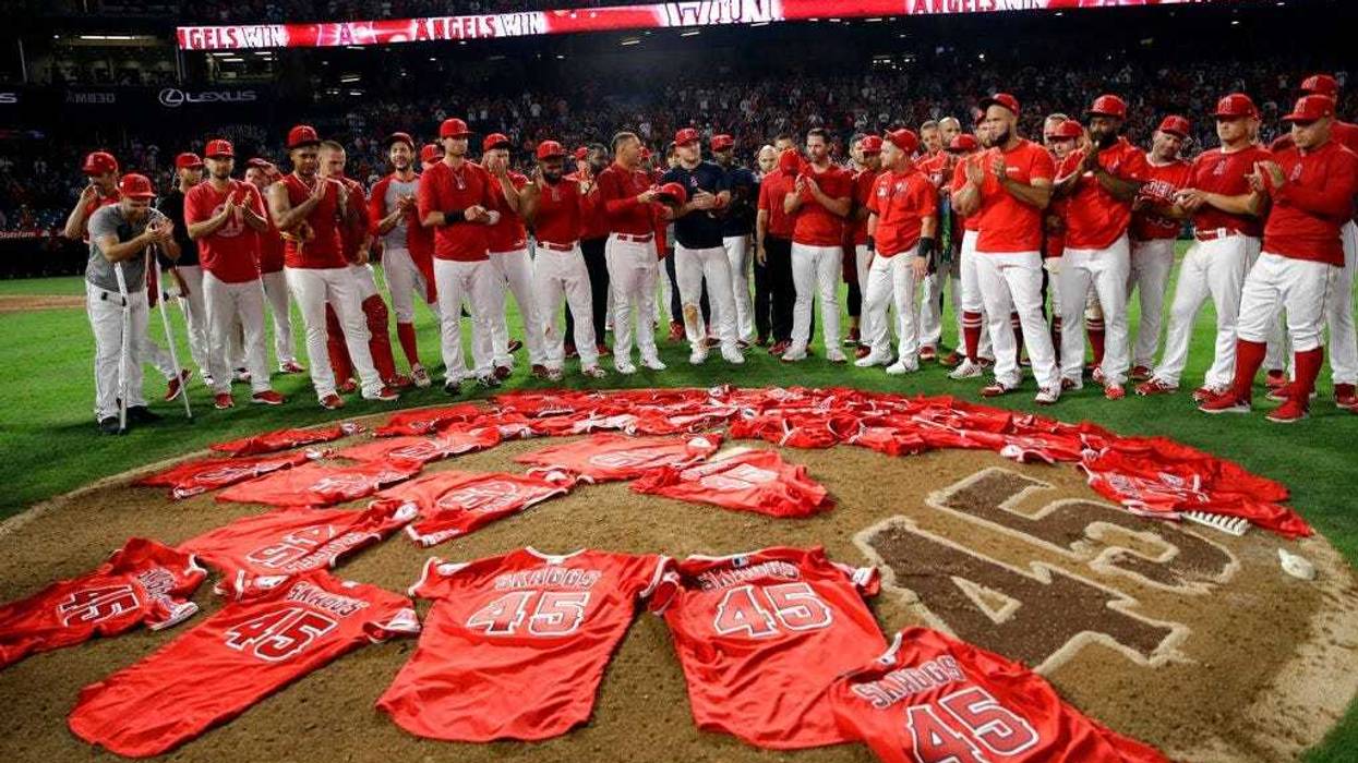 Members of the Los Angeles Angels place their jerseys with No. 45 in honor of pitcher Tyler Skaggs on the mound after a combined no-hitter against the Seattle Mariners during a baseball game Friday, July 12, 2019, in Anaheim, Calif.