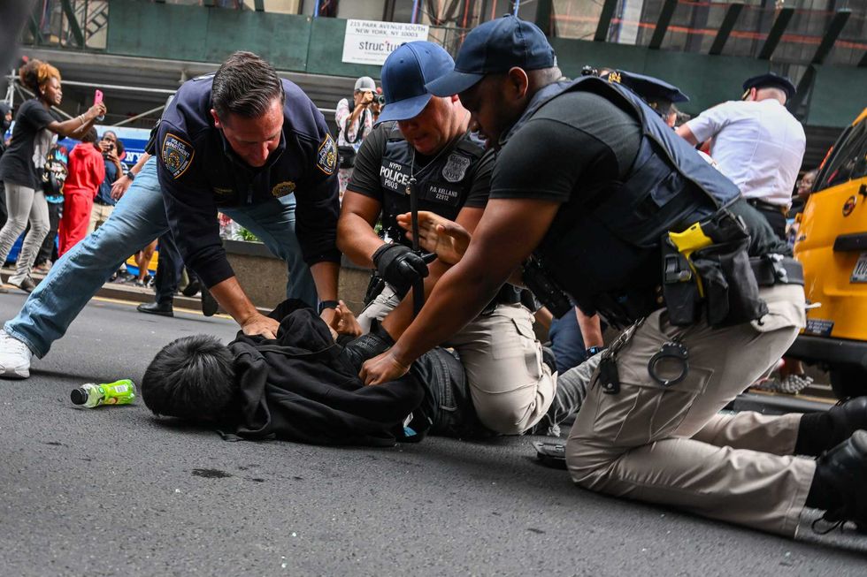 Members of the NYPD arrest people after responding to thousands of people gathered for a "giveaway" event in Union Square and the surrounding area on Aug. 4, 2023