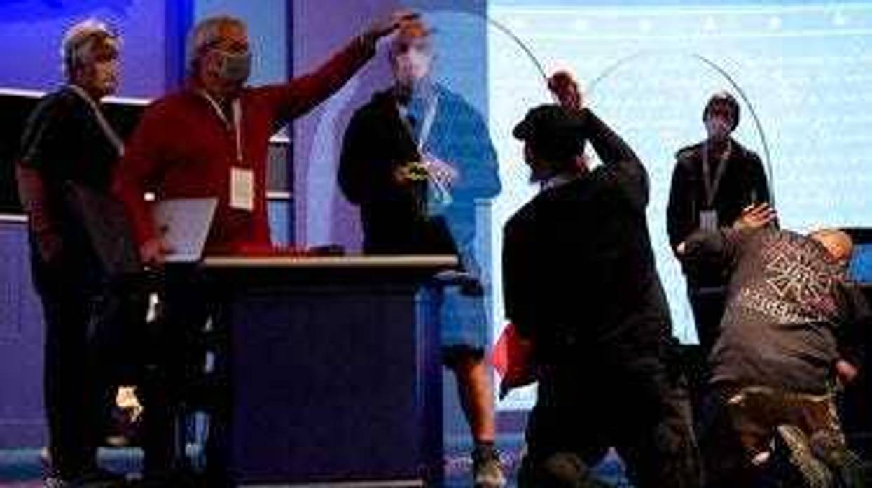 Members of the production crew inspect glass on stage which will serve as a barrier to protect the spread of COVID-19 as preparations take place for the vice presidential debate at the University of Utah in Salt Lake City. (AP Photo/Julio Cortez)