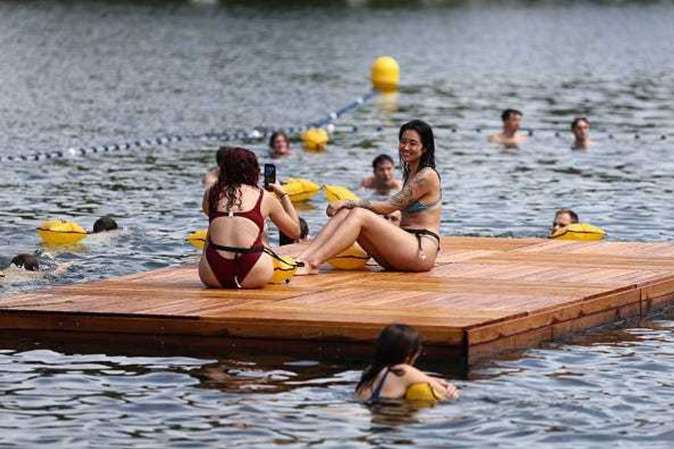Members of the public swim at the Baignade de Grenelle bathing site on its opening day on July 5, 2025 in Paris, France. Mayor of Paris Anne Hidalgo is visiting three bathing sites as the city launches its inaugural season of public swimming in the River Seine for the first time in just over a hundred years. Hidalgo had made it a promise of her time in office to make the Seine swimmable again ahead of the 2024 Summer Olympics in Paris, with the city investing 1.4 billion euros in a clean-up project. Swimming in the Seine had been banned since 1923, due to the dangers of boat traffic and poor water quality. The new bathing areas offer changing areas and will be monitored by life guards for the swimming season, from July 5 to August 31. (Photo by Tom Nicholson/Getty Images)