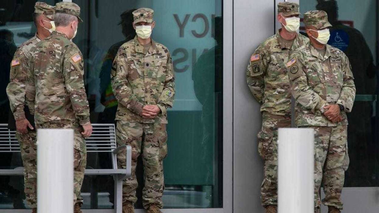 Members of the U.S. Army Corps of Engineers stand outside the Miami Beach Convention Center as they build a coronavirus field hospital inside the facility on April 8, 2020 in Miami Beach, Florida.