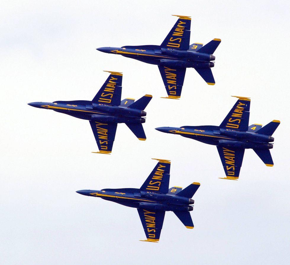 Members of the U.S. Navy Blue Angels do a maneuver as they fly over Lake Michigan August 22, 2004 in Chicago, Illinois. The U.S. Navy Blue Angels were one of many airplane groups that participated in the 46th annual Chicago Air and Water Show in the skies over Chicago