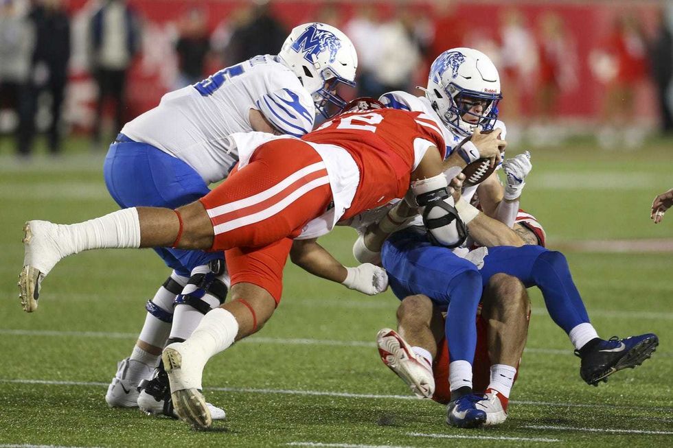 Memphis Tigers quarterback Seth Henigan (14) is sacked by Houston Cougars defensive lineman Logan Hall (92) in the first quarter at TDECU Stadium.