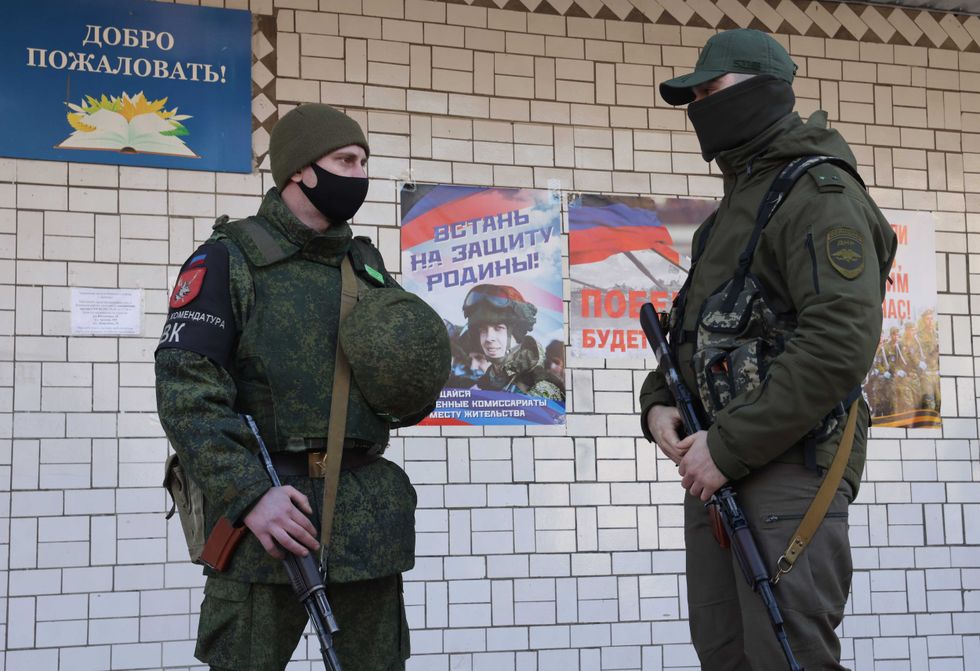 Men are seen outside a mobilization station of the military commissariat for Donetsk