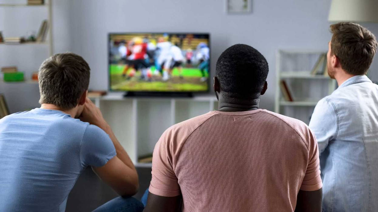 Men watching a football game stock photo.