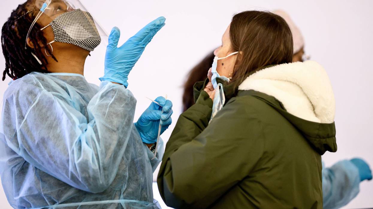 Merline Jimenez (L) provides direction before administering a COVID-19 nasopharyngeal swab to a person at a testing site located in the international terminal at Los Angeles International Airport (LAX) amid a surge in Omicron variant cases on December 21, 2021 in Los Angeles, California.