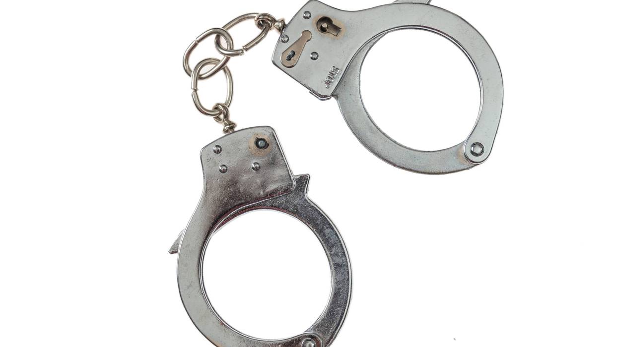Metal locked handcuffs isolated on white background