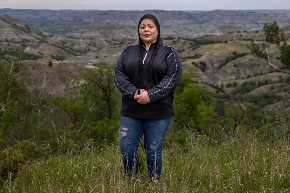 MHA Drug Enforcement special agent, Dawn White, stands in front of one of her favorite parts of North Dakota, the Badlands area south of the Fort Berthold Reservation. White is an Army veteran who grew up on the Fort Berthold Reservation and worked as a Sgt. for the Tribal Police before joining the specialized drug task force based in Parshall, North Dakota. June 25, 2021. As 9633 Powwow Police Northdakota Pipeline451