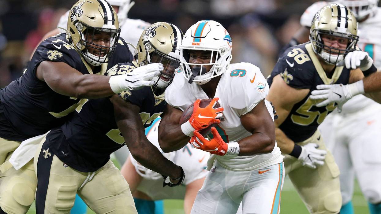 Miami Dolphins running back Mark Walton (9) is chased by New Orleans Saints defensive tackle Shy Tuttle (74) and defensive back Chauncey Gardner-Johnson (22) in the first quarter at the Mercedes-Benz Superdome.