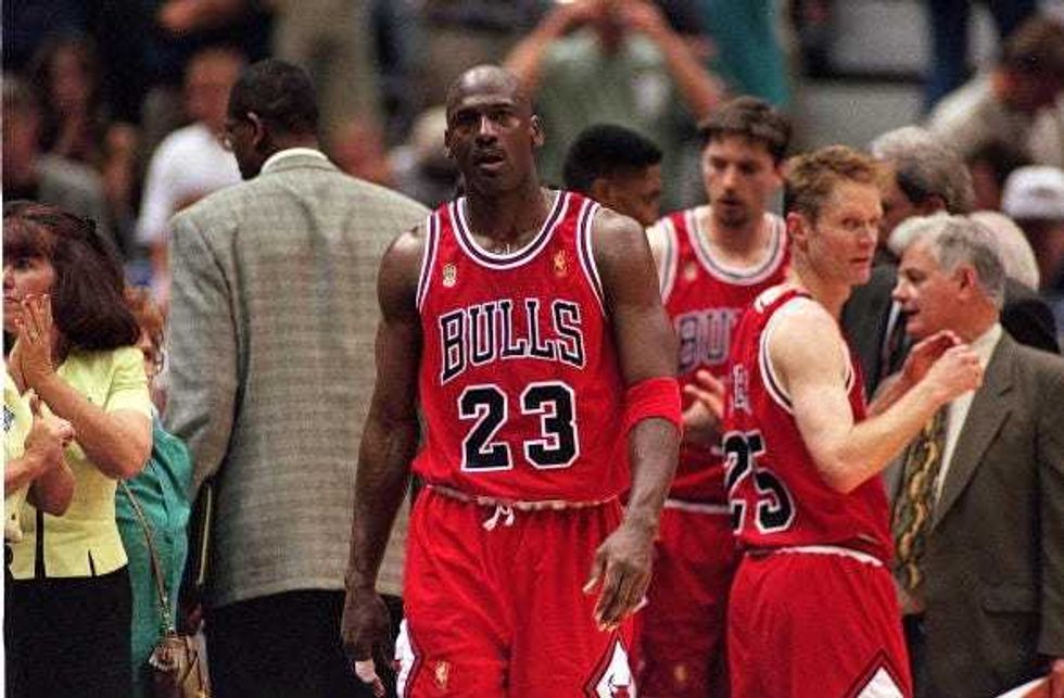 Michael Jordan walks out of a Bulls huddle during a timeout.