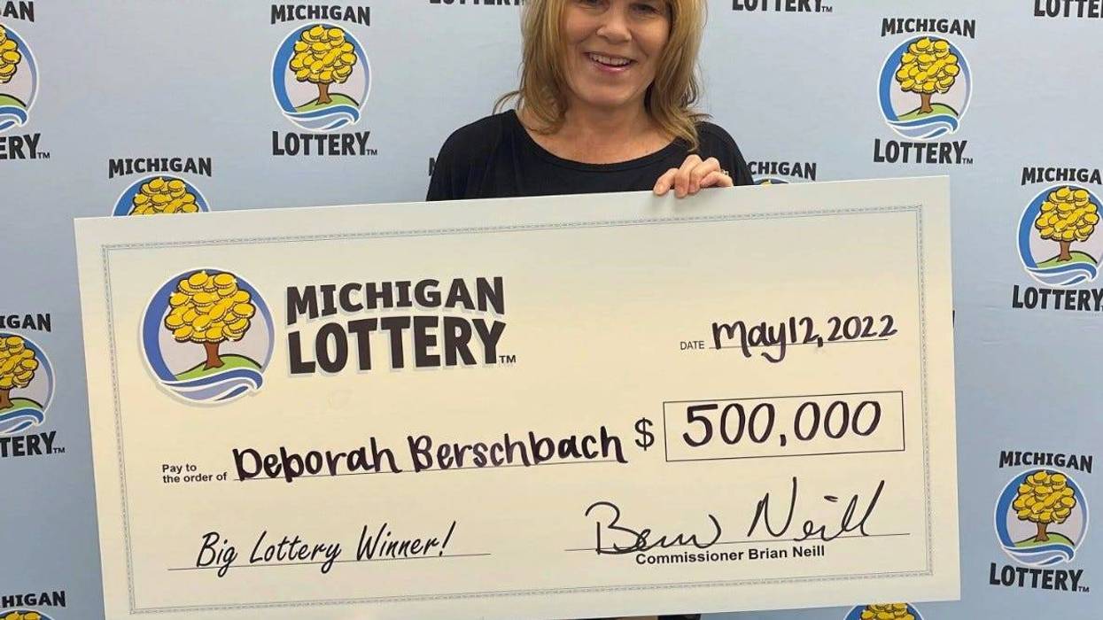 Michigan Lottery winner holding check