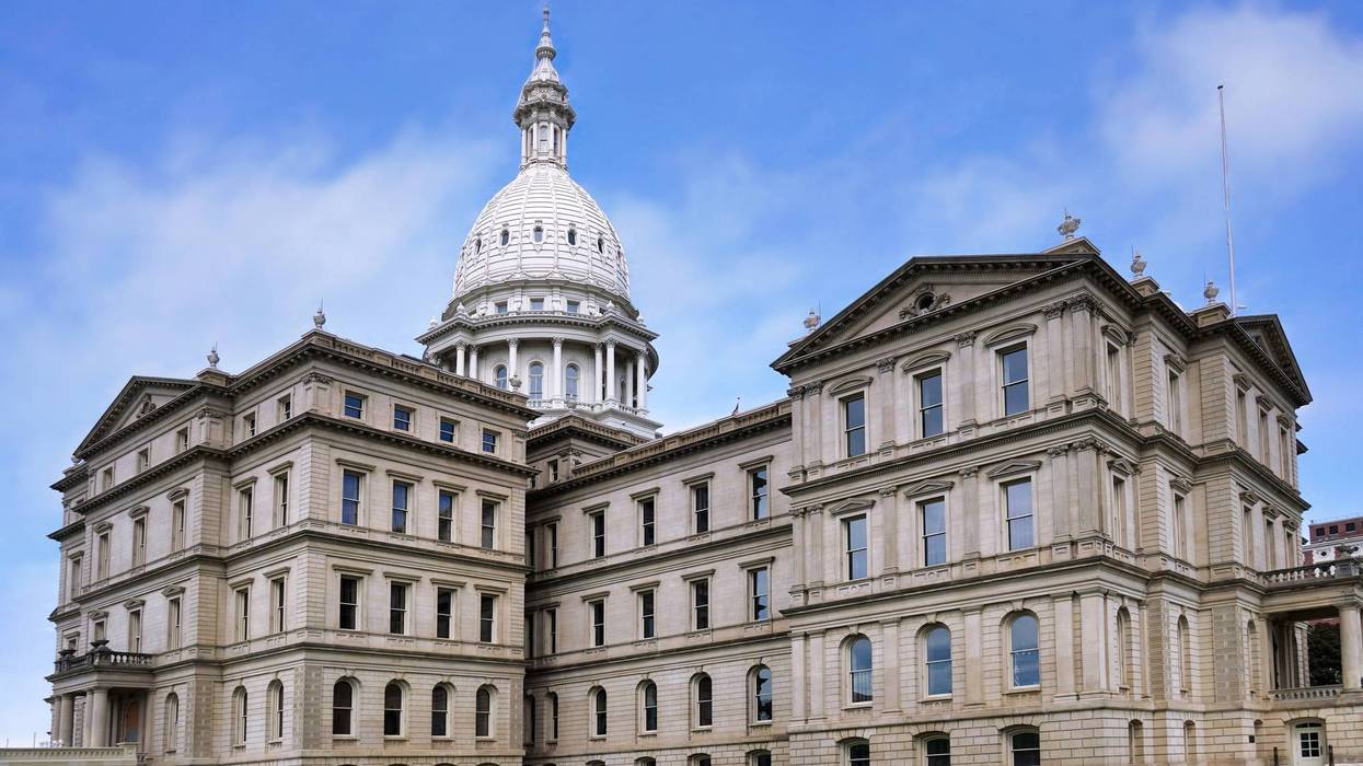 Michigan State Capitol building with its white dome against a partly cloudy blue sky.
