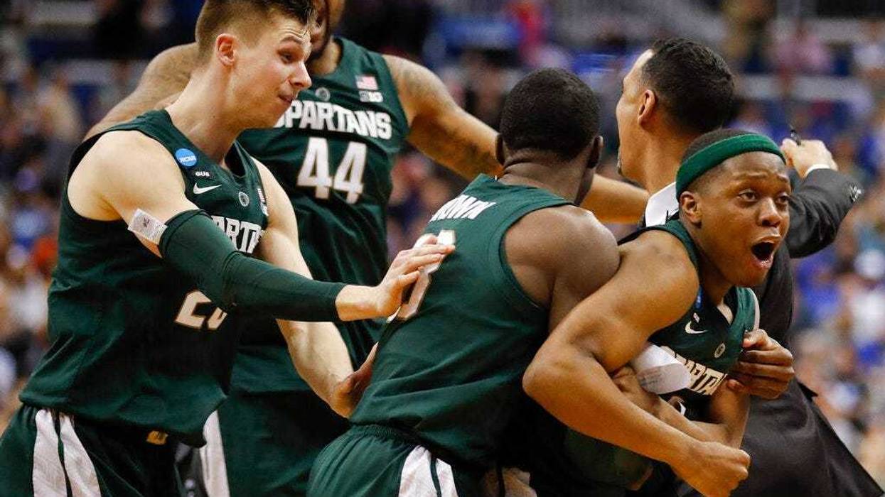 Michigan State guard Cassius Winston, right, celebrates with teammates Matt McQuaid (20), Nick Ward (44) and Gabe Brown (13) after defeating Duke in an NCAA men's East Regional final college basketball game in Washington, Sunday, March 31, 2019.