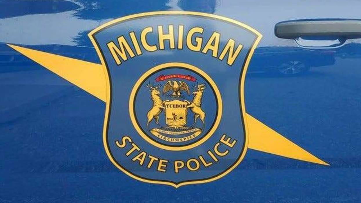 Michigan State Police emblem, blue & gold, on a patrol car.