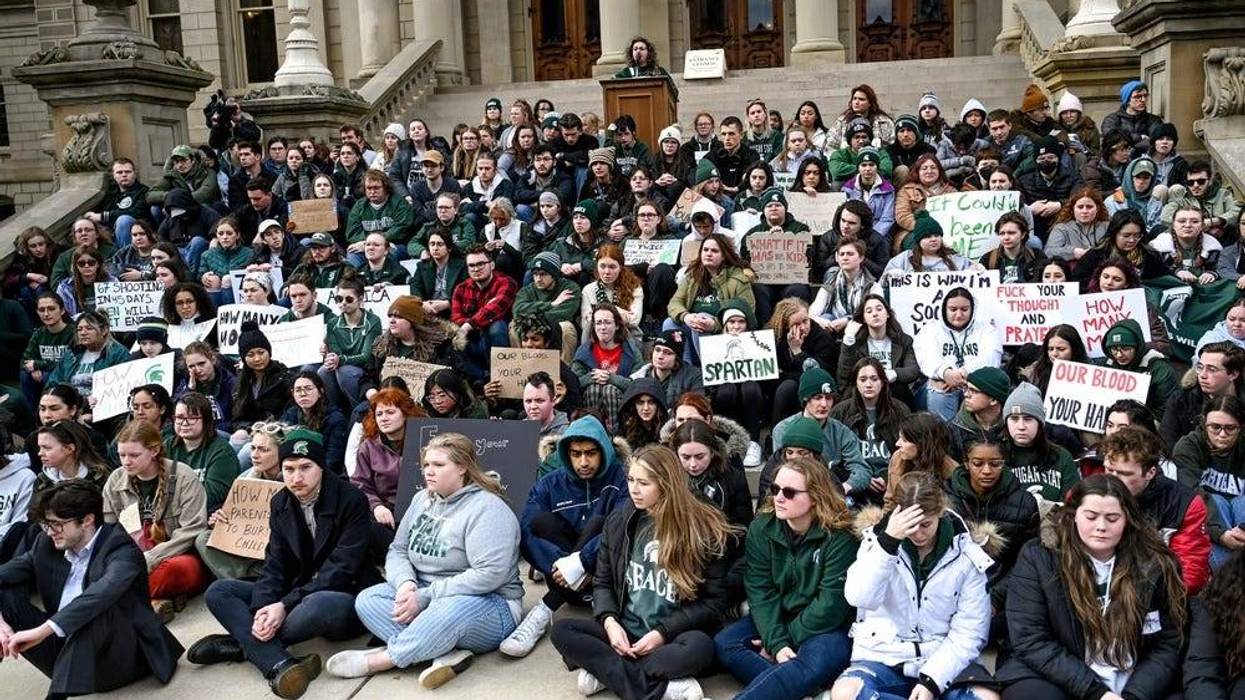 Michigan State University students gather on the front steps of the Capitol