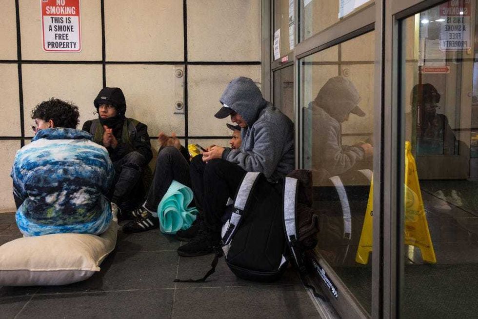 Migrants speak amongst themselves as they camp out in front of the Watson Hotel after being evicted on January 30, 2023 in New York City.