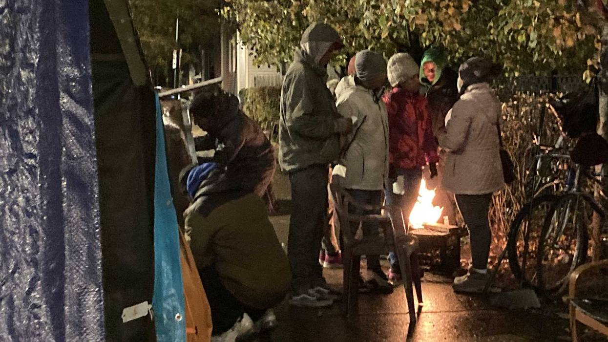 migrants standing over grill