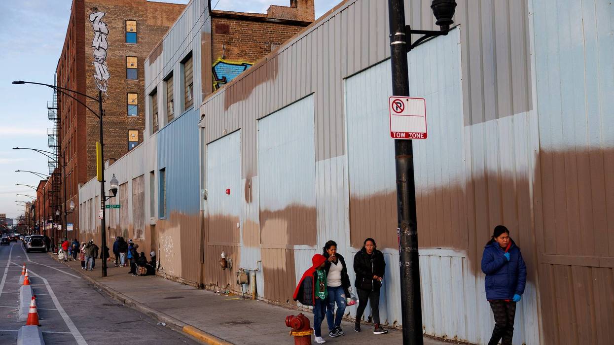 Migrants walk outside a shelter where they're staying near the 2300 block of South Halsted Street on Tuesday Dec. 19, 2023, in Chicago.