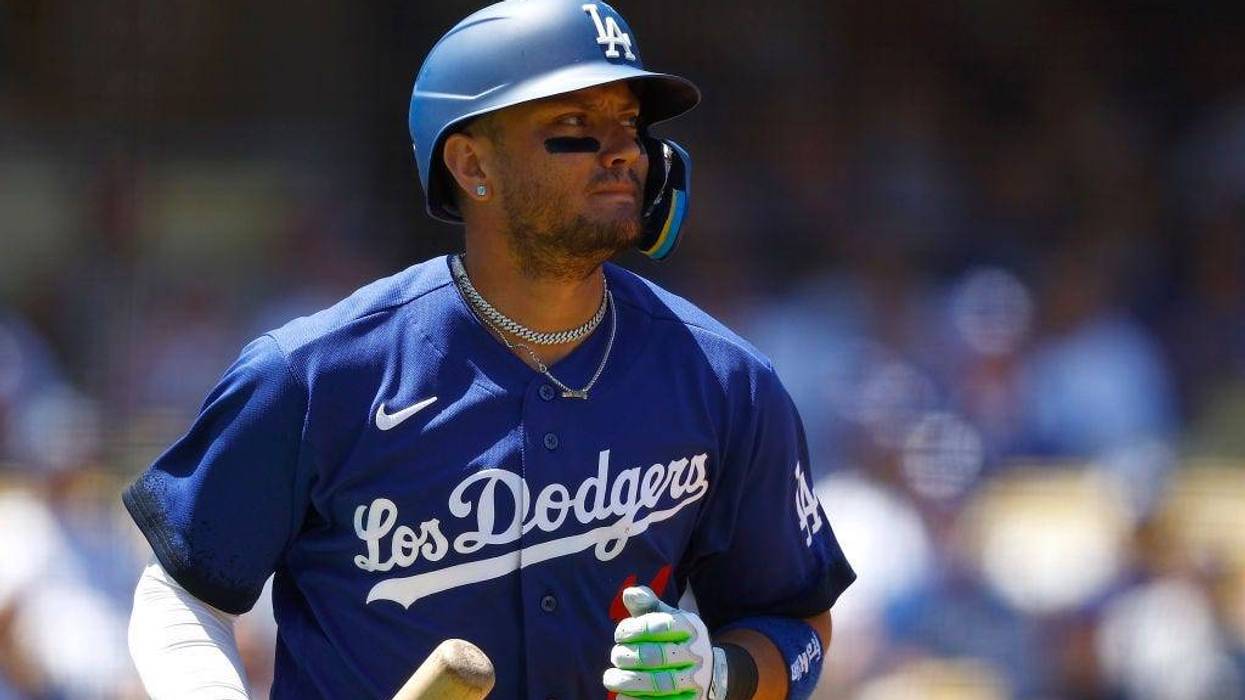 Miguel Rojas #11 of the Los Angeles Dodgers scores a run on a fly out against the Colorado Rockies in the second inning at Dodger Stadium on August 13, 2023 in Los Angeles, California.