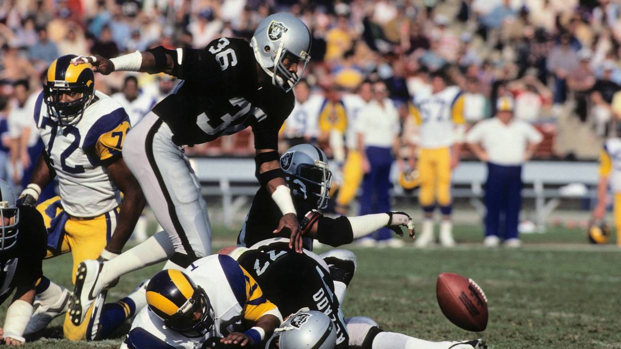 Mike Davis #36 of the Los Angeles Raiders chases after a fumble caused by teammate Lyle Alzedo #77 on running back Wedell Tyler #26 of the Los Angeles Rams during the game at the Los Angeles Memorial Coliseum on December 18, 1982